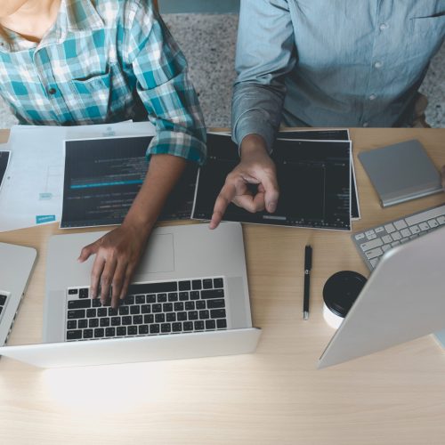 Developing programming and coding technologies working in a software engineers developing applications together in office.