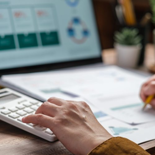 close up hand using calculator calculate tax and budget of project at home